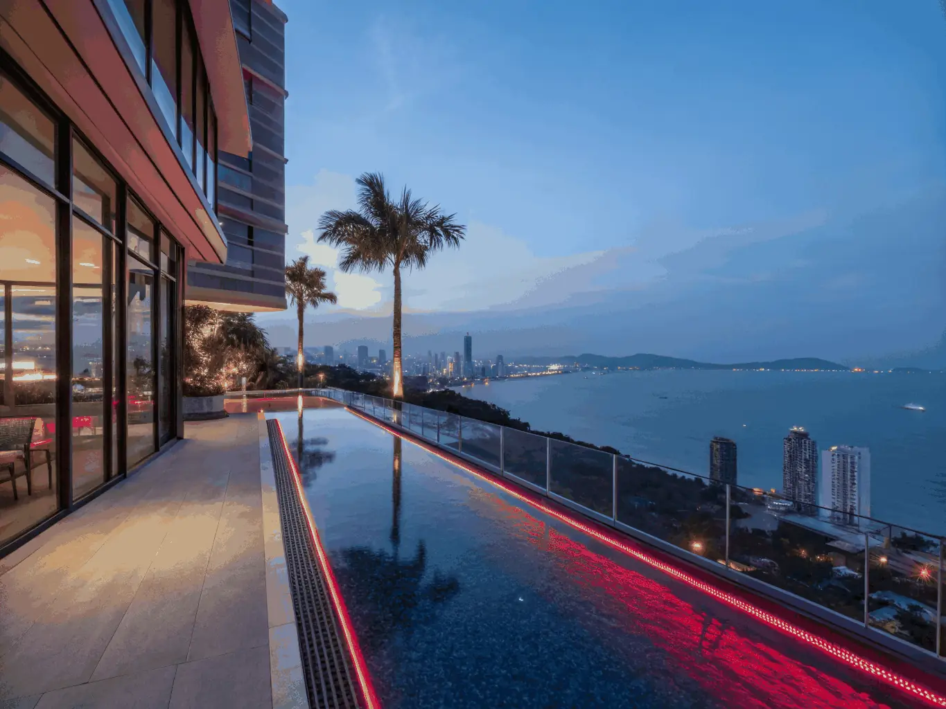 Exterior of a modern hotel with a pool in Pattaya, Thailand.