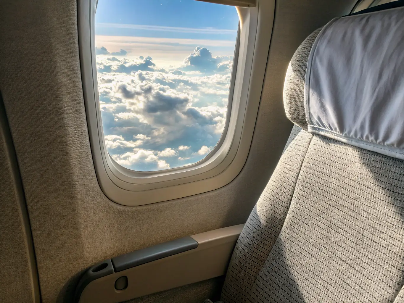A photo of an economy-class airline seat with a focus on the entertainment system and provided amenities, such as a blanket and pillow. The image aims to show comfort and value for budget-conscious travelers.